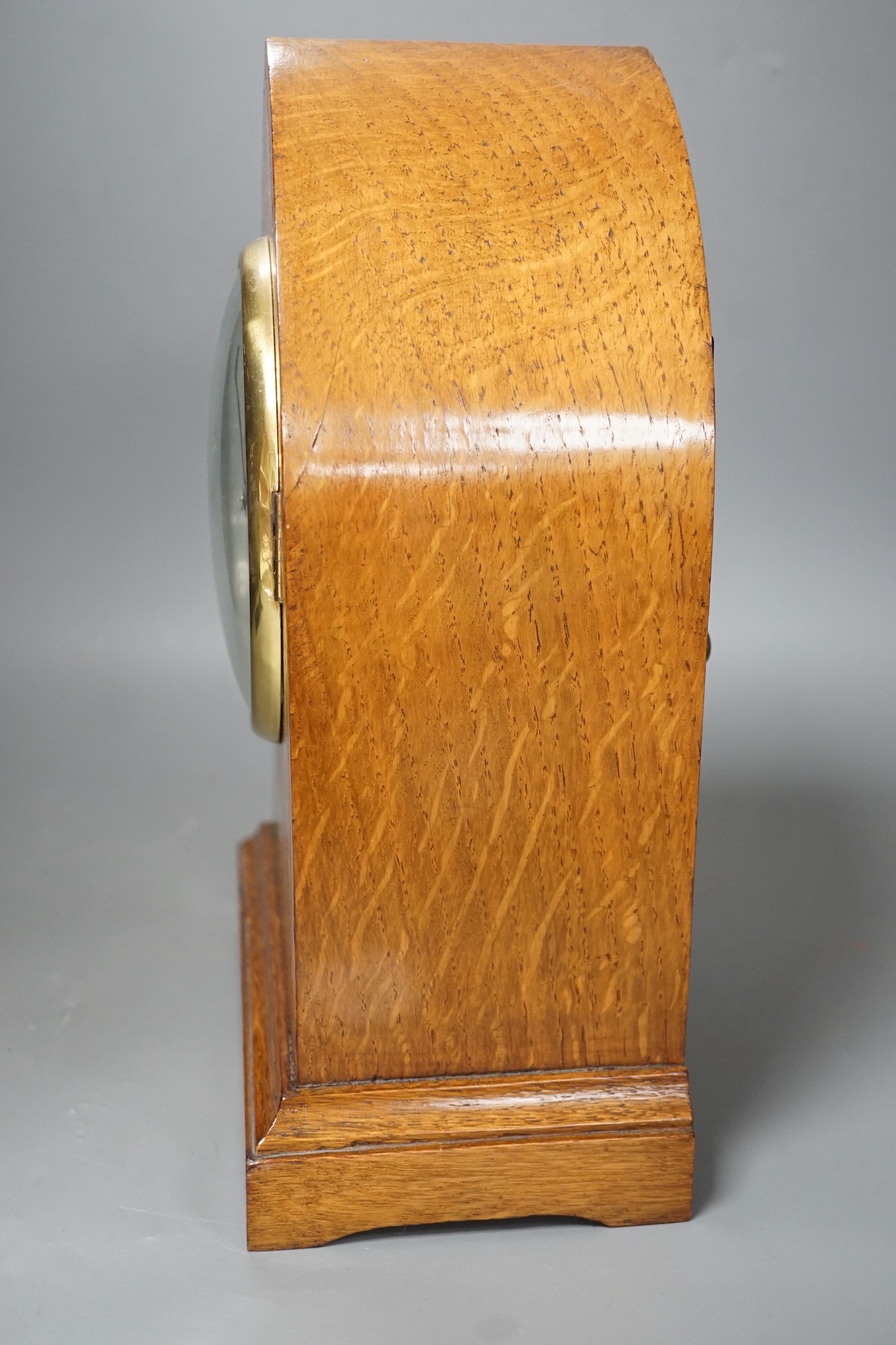 A pair of ebony rhinoceros book ends, together with an Edwardian oak lancet mantel clock, 35cm high